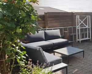 a couch and a coffee table on a patio at Classic Stavanger Townhouse, Garden, Spacious in Stavanger