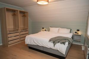 a bedroom with a large bed with white sheets at Classic Stavanger Townhouse, Garden, Spacious in Stavanger