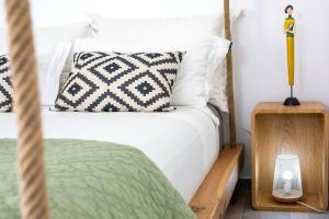 a bedroom with a white bed and a wooden night stand at Elite Houses Santorini in Emporio