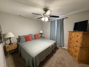 a bedroom with a bed with a ceiling fan and a television at Branson Ridge Retreat in Branson