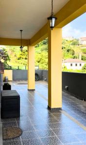 a patio with yellow columns and a table on the floor at Ocean Hill House by Rentery Madeira in Santa Cruz