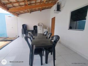 a dining room with a black table and black chairs at Espaço Acácia in Petrolina