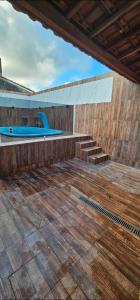 an outdoor deck with a pool and stairs on a building at Cantinho de conforto in Mongaguá
