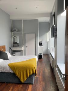 a bedroom with a bed with a yellow blanket on it at School house Portaferry in Portaferry