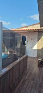 a wooden deck with a swimming pool in a house at Cantinho de conforto in Mongaguá