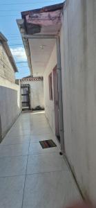 an empty alley with a door in a building at Cantinho de conforto in Mongaguá +2 photos