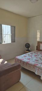 a bedroom with a bed and a window at Cantinho de conforto in Mongaguá