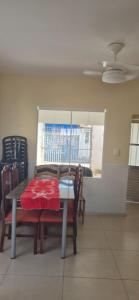 a dining room with a table and chairs and a window at Cantinho de conforto in Mongaguá
