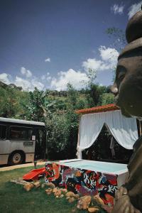 a bed in a field with a bus in the background at Ônibus Oriental com Ofurô - Domingos Martins ES in Domingos Martins
