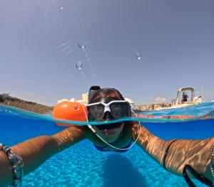 a woman in a snorkeling mask and goggles in the water at B&B La Dimora di Lulù in Trapani