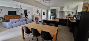 a kitchen and living room with a table and chairs at Maison Monéteau 6 personnes in Monéteau
