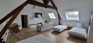 a living room with a couch and a chair in a attic at Maison Monéteau 6 personnes in Monéteau