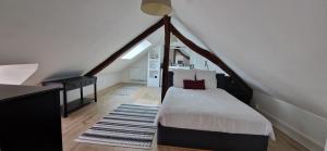 a bedroom with a bed in a attic at Maison Monéteau 6 personnes in Monéteau