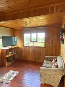 a living room with a couch and a flat screen tv at Cabañas centro Quellón in Quellón