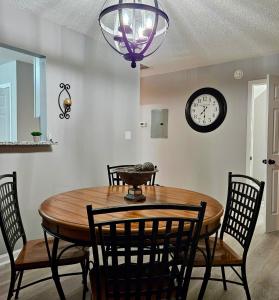 a dining room table with chairs and a clock on the wall at Convenient 3 bedroom Townhome in Raleigh