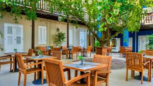 an empty restaurant with wooden tables and chairs at Atelier Skalo Boutique Hotel in Willemstad +66 photos