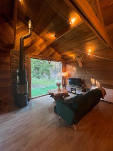 a living room with a couch and a fireplace at Auvers Wood lodge in Auvers-sur-Oise