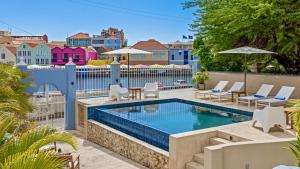 a swimming pool on a balcony with chairs at Atelier Skalo Boutique Hotel in Willemstad