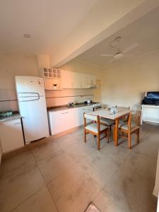 a kitchen with a table and a white refrigerator at Lo de Mingo in San Pedro
