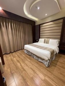 a bedroom with a large bed and a wooden floor at اجنحة سبات الفندقيه in Ahad Rafidah +19 photos