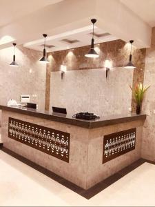 a kitchen with a counter with some pendant lights at اجنحة سبات الفندقيه in Ahad Rafidah