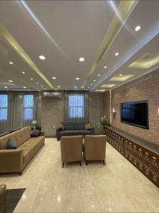 a large living room with couches and a flat screen tv at اجنحة سبات الفندقيه in Ahad Rafidah