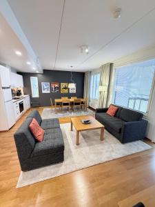a living room with two couches and a table at Premium Chalet huoneisto kylpylän vieressä in Vierumäki