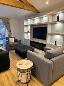 a living room with two couches and a tv at The Brambles bungalow in Weston-super-Mare