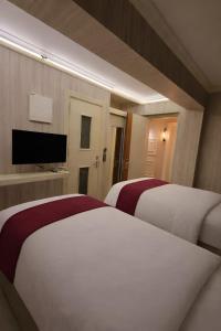 a hotel room with two beds and a flat screen tv at zebra otel buca in Buca