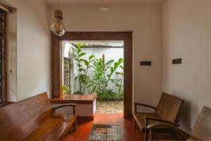a room with benches and a table and a window at The Oneness Living- Seasonal Heritage stay with Tholpaavakoothu nights in Pazhayannūr