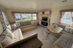 a living room with a couch and a table at Reeva's Resort at Littlesea Holiday Park, Weymouth in Wyke Regis