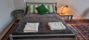 a bed with green and white pillows on it at Apartment 11 A in BRE