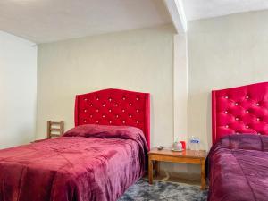 a bedroom with two beds with red covers and a table at Ruby Grey Suite in Mineral de Angangueo +6 photos