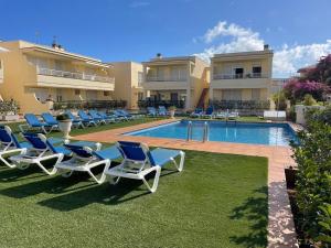 a group of lounge chairs and a swimming pool at Vinaros Cala Montero 2 in Vinarós