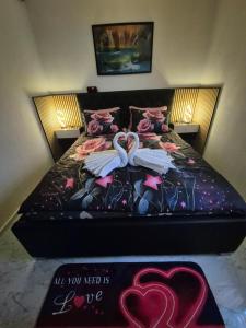 a bed with two swans on it with a sign at APARTMENt ANAYA in Bovec