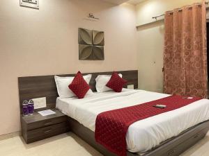 a bedroom with a large bed with red pillows at Tejas 4 Bhk Villa in Pune