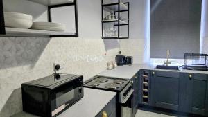 a kitchen with a microwave and a stove in it at The Maisonette central Buxton in Buxton