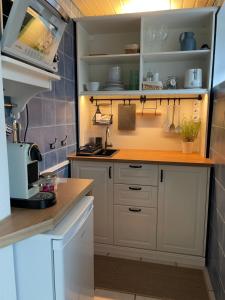 a kitchen with white cabinets and a counter at Ferienwohnung am Storchennest in Ichenhausen