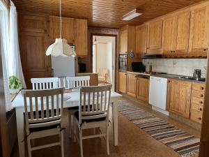 a kitchen with wooden cabinets and a table and chairs at Askebo Norregård in Askebo