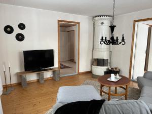 a living room with a couch and a tv at Askebo Norregård in Askebo