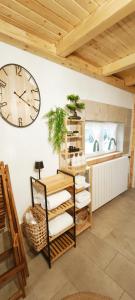 a clock on a wall next to a shelf at Kuća za odmor Delak in Fužine