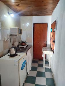 a small kitchen with a stove and a microwave at DepartamentosJYM in Federación