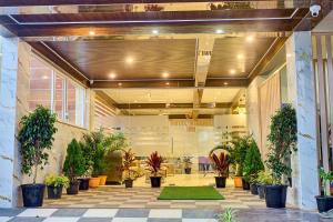 a lobby with potted plants in a building at Hotel Airline Inn - Near Kempegowda International Airport in Muthugadahalli