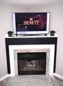 a flat screen tv over a fireplace in a living room at Convenient 3 bedroom Townhome in Raleigh