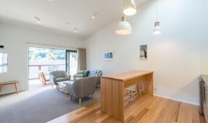 een woonkamer met een tafel en stoelen bij Kaiteriteri Reserve Apartments in Kaiteriteri