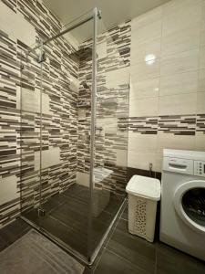 a bathroom with a shower and a washing machine at Saules home Jomas - early check in, late check out in Jūrmala +24 photos