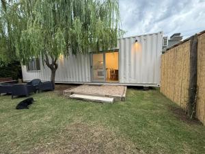 a tiny house in a yard with a tree at Container home in San Rafael