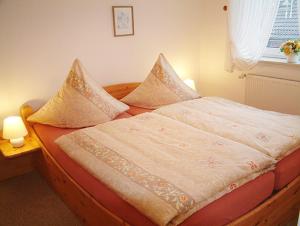 ein Bett mit zwei Kissen darauf in einem Schlafzimmer in der Unterkunft Haus Nordstrand Berliner Strasse 1a in Büsum