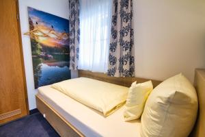 a small bedroom with a bed and a window at Zum Franziskaner in Grainau