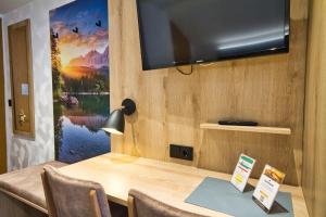 a room with a desk with a television on a wall at Zum Franziskaner in Grainau +47 photos